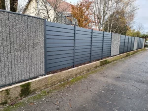 Clôture en aluminium avec panneaux de gabions, offrant une séparation moderne et robuste le long d'un chemin